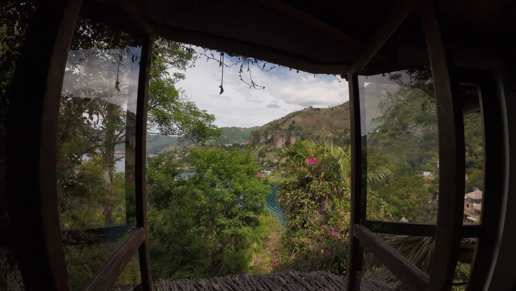 View through a round casita window across the lake to the mountains