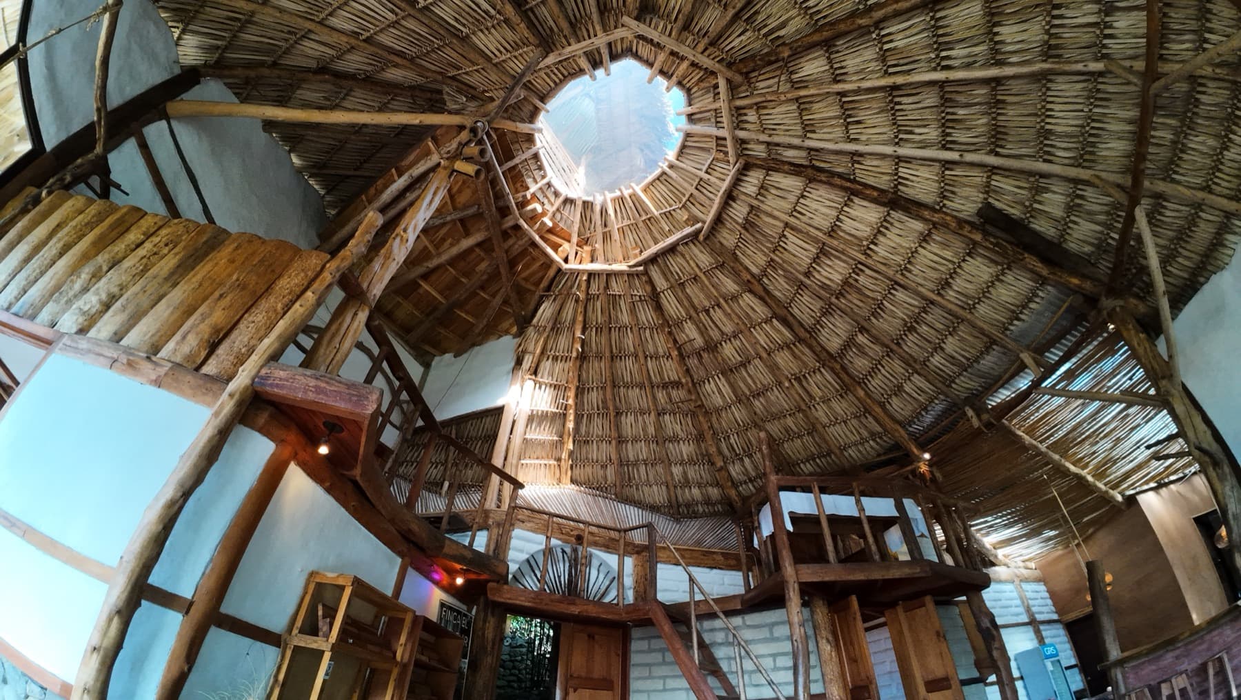 Looking up at El Taller's conical thatched ceiling and central skylight